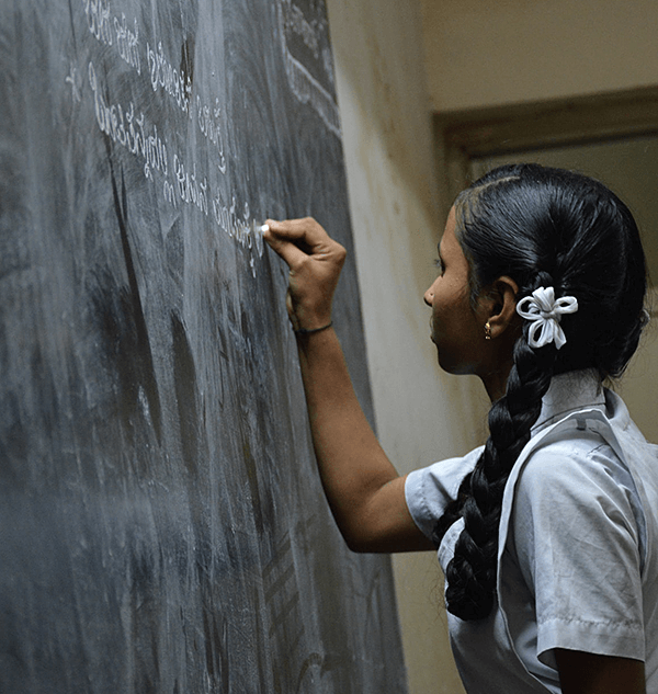 young girl writing on the class board